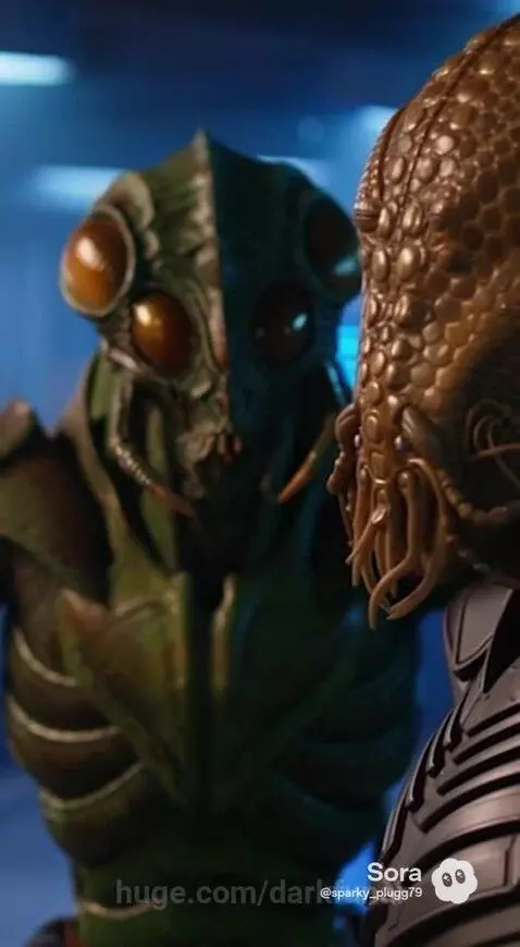 Reporter interviewing an alien with scaly skin and tentacles, looking shocked.