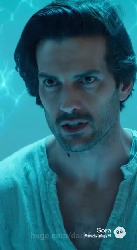 Man and woman in futuristic chamber, discussing burning stars and a 50,000-year confrontation.