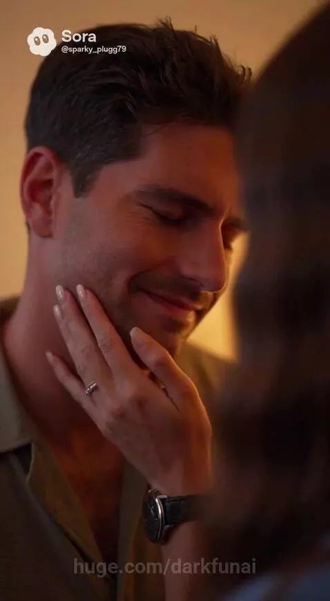 Couple sharing a romantic kiss in a bedroom with warm lighting.