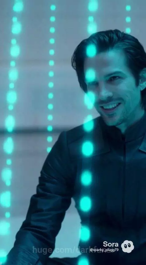 Woman in a futuristic chamber, wearing a green dress and golden headpiece, crying as she confronts a man.