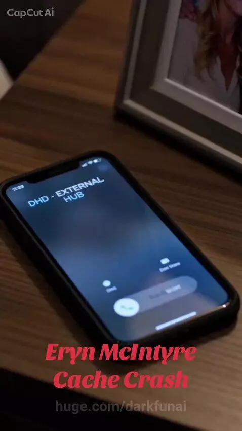 Man with gray hair and beard in leather jacket looks concerned while answering a phone call on a rainy night.