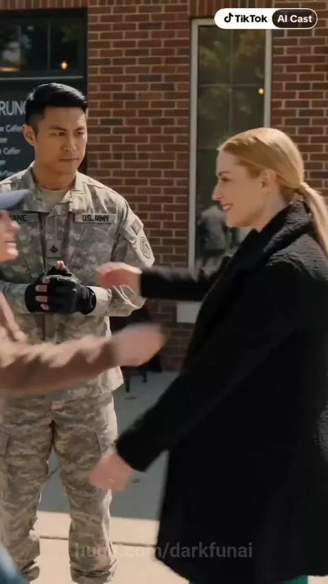 Woman in green dress hugs woman in blue cap and brown hoodie, with a soldier nearby.