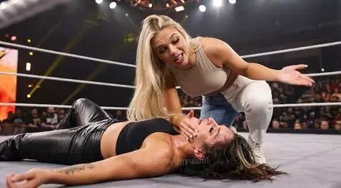 Wrestler Julia Hart taunts Jamie Hayter after defeating her in a wrestling match, kissing her on the mouth.