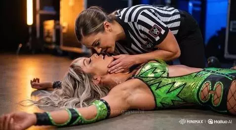 WWE referee in striped shirt leaning over and kissing a female wrestler lying on the ground.