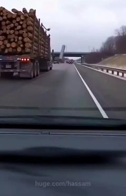 A log has just hit and shattered a car's windshield, obscuring the view from inside the vehicle.