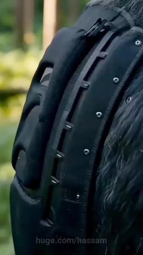 Woman in a mechanical gorilla suit standing among other gorillas in a forest, evading searchers.