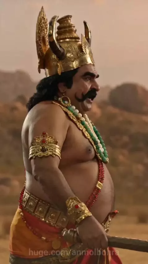 Hanuman with a monkey face in golden crown fights a horned demon with a mace in a desert landscape.