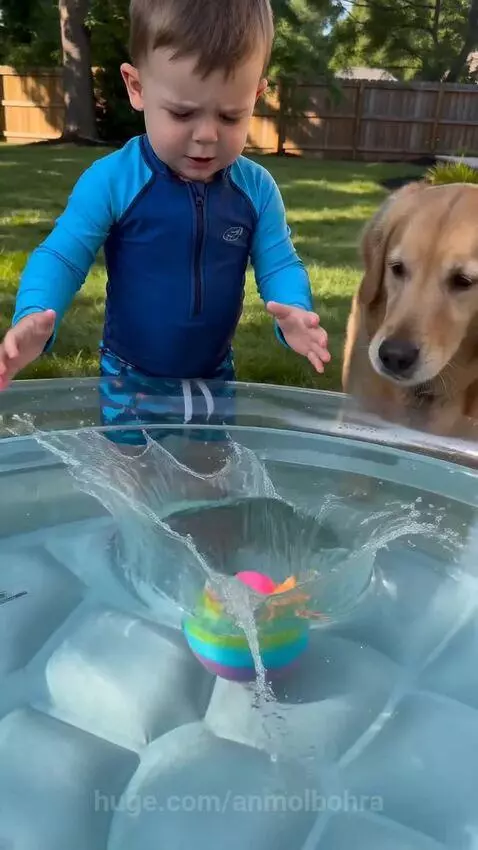 Child dropping a rainbow dinosaur egg into a pool, dog watches, colorful foam emerges.