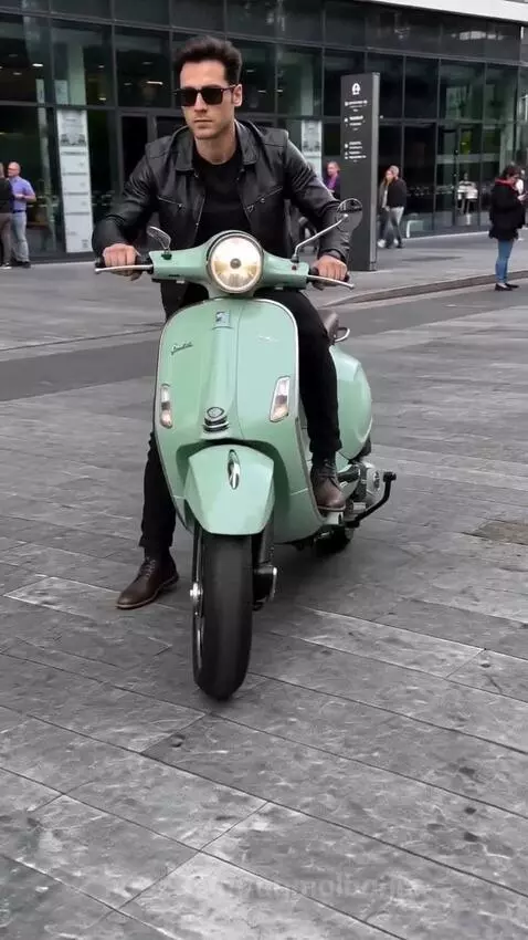 Mint green vintage scooter transforming into a complex mechanical serpent with multiple wheels and exhaust pipes.