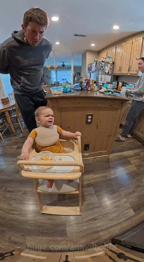 Baby in high chair pointing at dad, demanding snacks with 'Hands!'