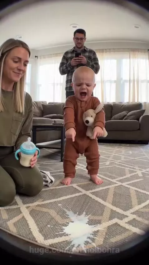 Baby crying loudly after milk spills, then laughing and clapping with joy.
