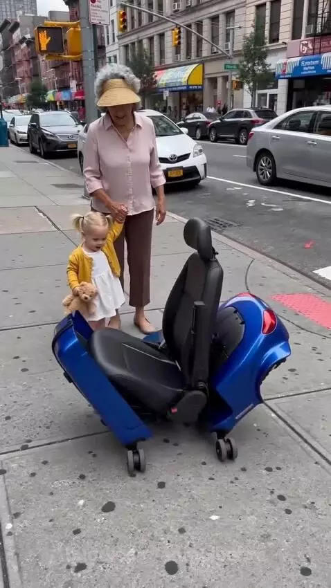 Elderly woman and child on a transforming suitcase scooter, smiling.