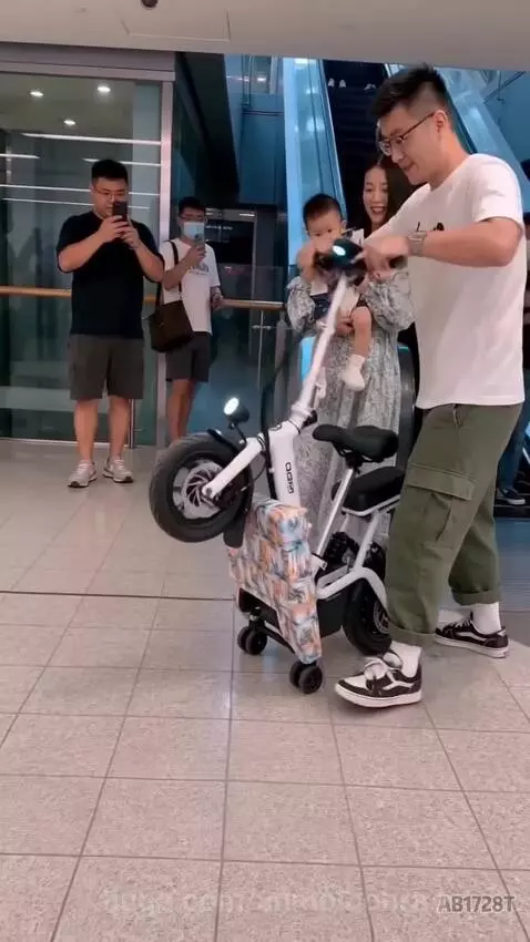 Family smiling on a compact electric scooter that transformed from a patterned bag, with escalators in the background.