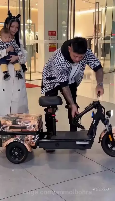 Man assembles a foldable electric tricycle with a canopy, then rides it with a woman and baby.