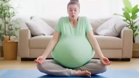 Woman in lotus position with dramatically inflating belly during breathing exercise.