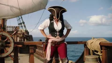 Pirate captain in costume on a ship deck, smiling with a visibly expanded, large, round belly.