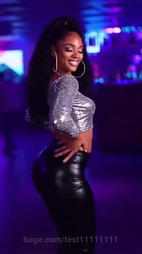Woman with long curly hair in a sequined top dancing in a club, her hips rapidly expanding to an exaggerated size.