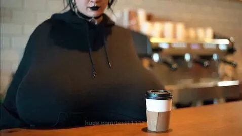 Woman with black hoodie and lipstick holding a coffee cup, asking a question.