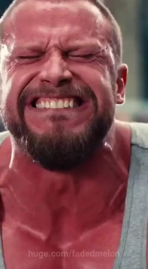 A gorilla reaching through an enclosure to assist a man lifting a very heavy barbell.