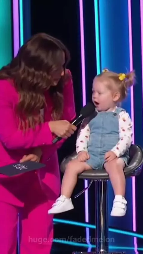 Host in pink suit laughs as a child in overalls says 'I like food' when asked about liking girls or boys.