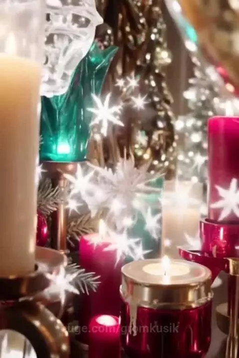 Close-up of lit white, red, and green candles in decorative holders with blurred sparkling holiday lights in the background.