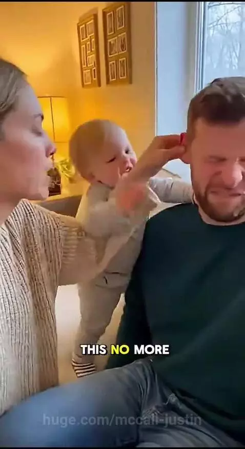 Baby mimicking mom pinching dad's ear, both looking serious and playful.