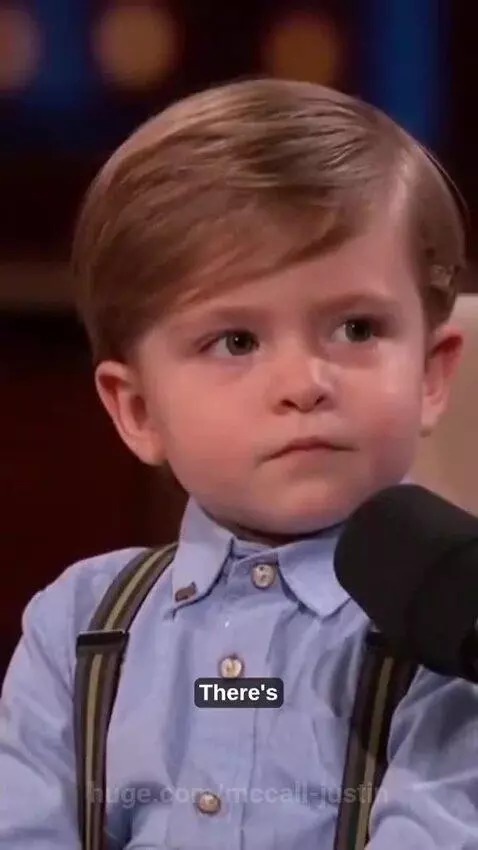 Young boy in a blue shirt and suspenders giving relationship advice on a talk show set.