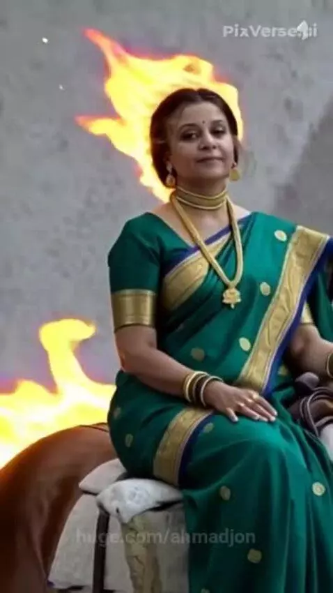 Woman in green and gold Indian saree on a brown horse with animated flames around their heads.