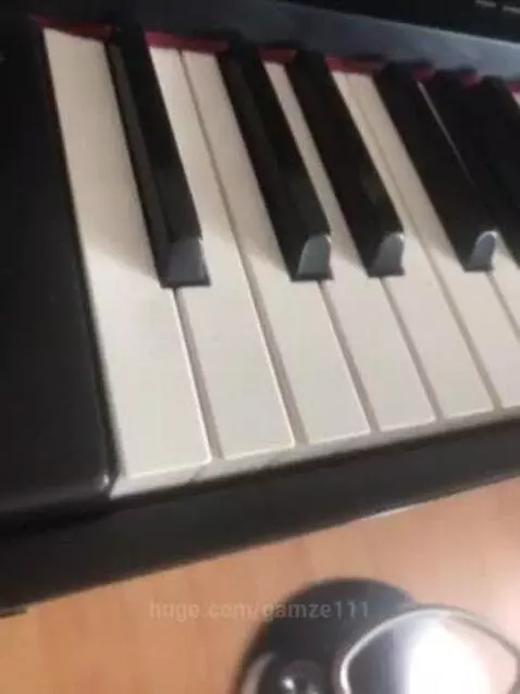 Close-up view of a black and white piano keyboard with reddish felt lining, suggesting a calm and inviting atmosphere.