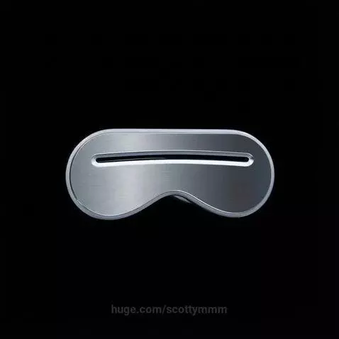 A sleek, metallic, silver object resembling a futuristic eye mask or visor with a central slot, rotating smoothly.