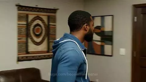 Man and woman meet and share an intimate kiss in a room.