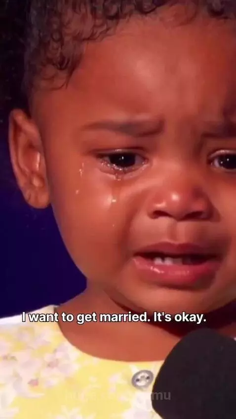 A young girl in a yellow dress crying on stage, explaining her desire to marry to share feelings.
