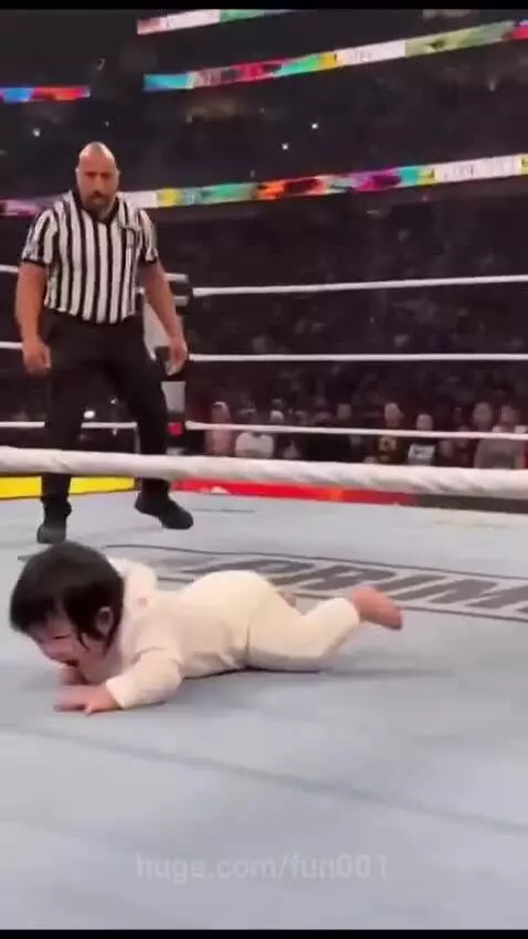 Baby in wrestling ring 'punches' The Rock, who dramatically falls. Baby celebrates victory.