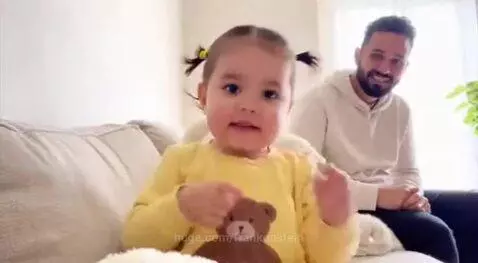 Young girl with pigtails playfully warns viewers to stay away from her dad, pointing to his wedding ring.