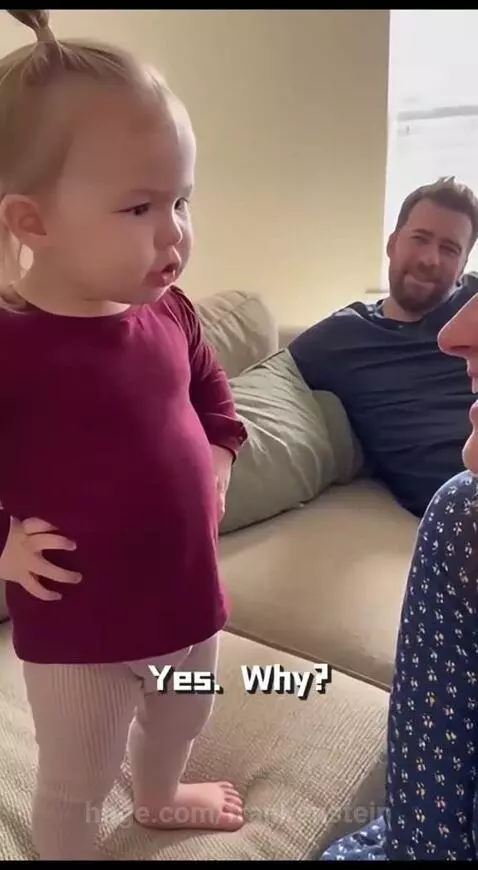 Young child with blonde pigtails and serious expression warns an adult woman away from her father.