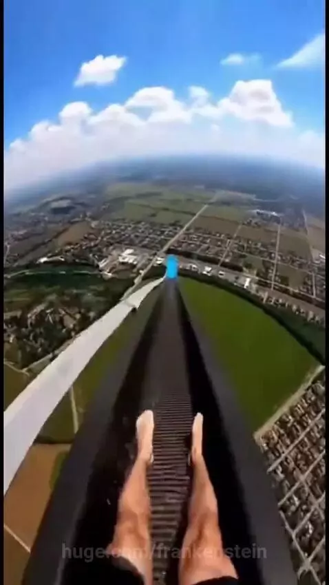 Person with curly hair screaming and flailing on a couch, reacting to a water slide.