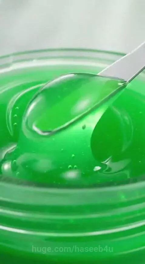 Green gel mask with basil leaves and molecular structures, showing texture and application on faces.