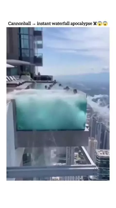 A man jumps into a glass-sided skyscraper pool, causing it to shatter and water to cascade down the building.