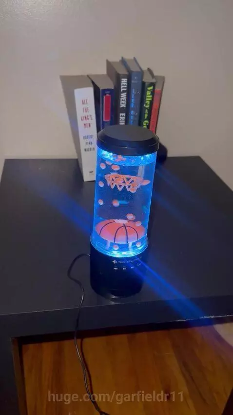 Basketball hoop shaped liquid lamp with orange beads floating and changing colors.