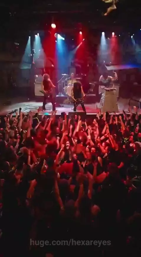 Misfits of Chaos metal band singer with red clown nose crowd-surfing during a live concert with red and blue lights.