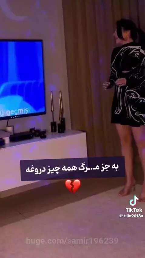 Woman in patterned dress singing karaoke in a living room, with Turkish lyrics on screen.