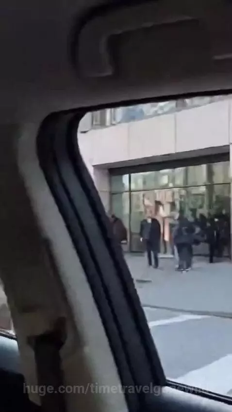 Man dressed as a Viking with helmet and beard rides an electric scooter down a busy city street.