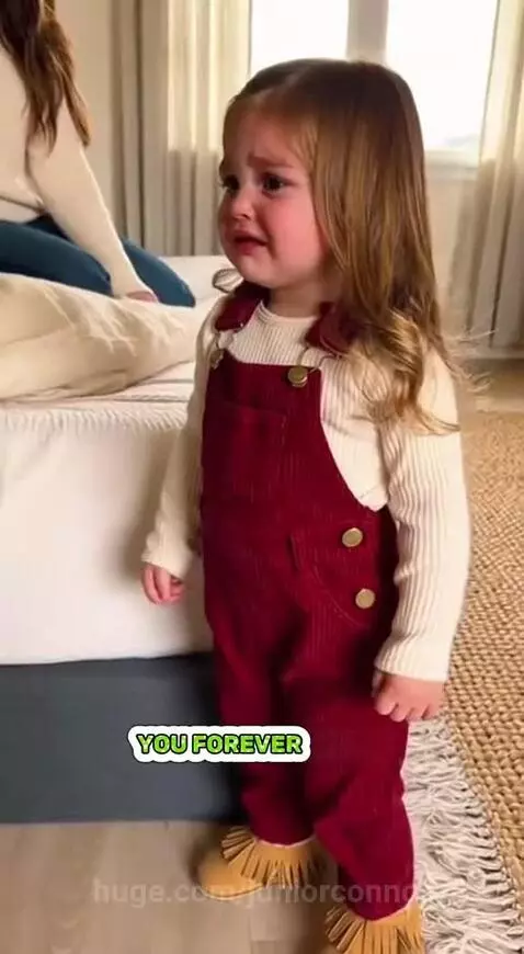 A young girl looks upset and cries while her father holds and kisses a newborn baby.