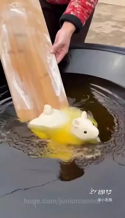 A raw dough animal figure rapidly expands and transforms into a textured, golden-brown fried sheep with horns in hot oil.