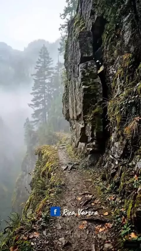 Person in military attire escaping a hidden bunker via hang glider over a misty mountain landscape.