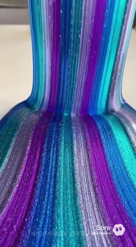 Close-up of shimmering blue, purple, teal, and silver slime stretching and flowing.