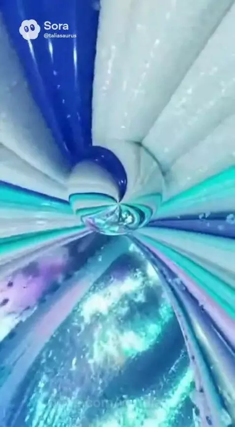 Abstract animation of swirling blue, white, and turquoise colors forming a tunnel around a rotating sphere with sparkling lights.