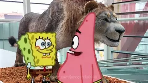 Spongebob and Patrick stand before a large, realistic statue of a Eurasian Cave Lion in an indoor public space.