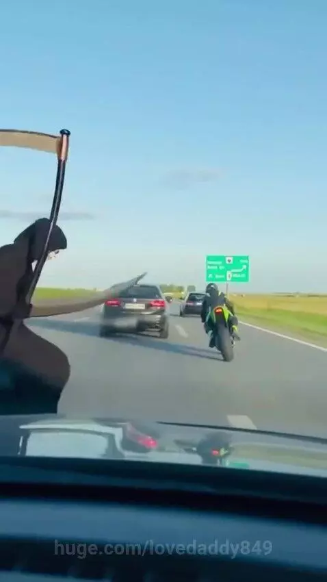 Dashcam view of a highway with people dressed as Jesus and the Grim Reaper running in front of cars.