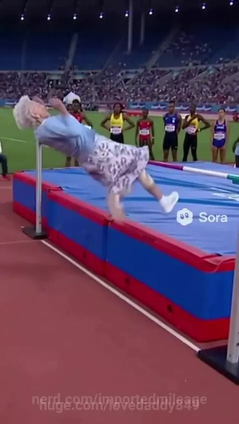 Elderly woman in blue cardigan and patterned skirt attempts a high jump, clearing the bar and falling onto the track.